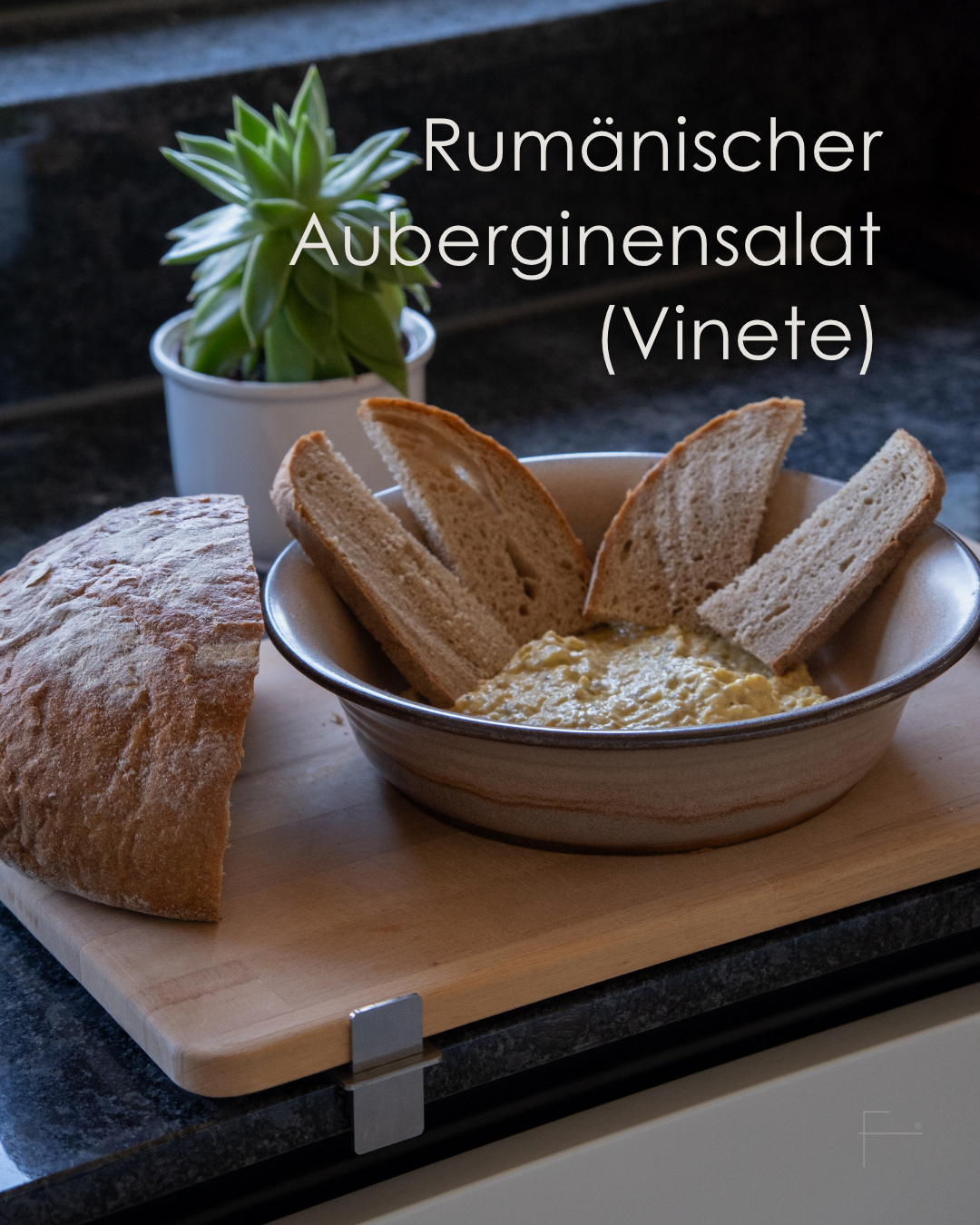 Rumänischer Auberginenaufstrich Vinete mit Brot auf einem Schneidebrett in der Küche serviert