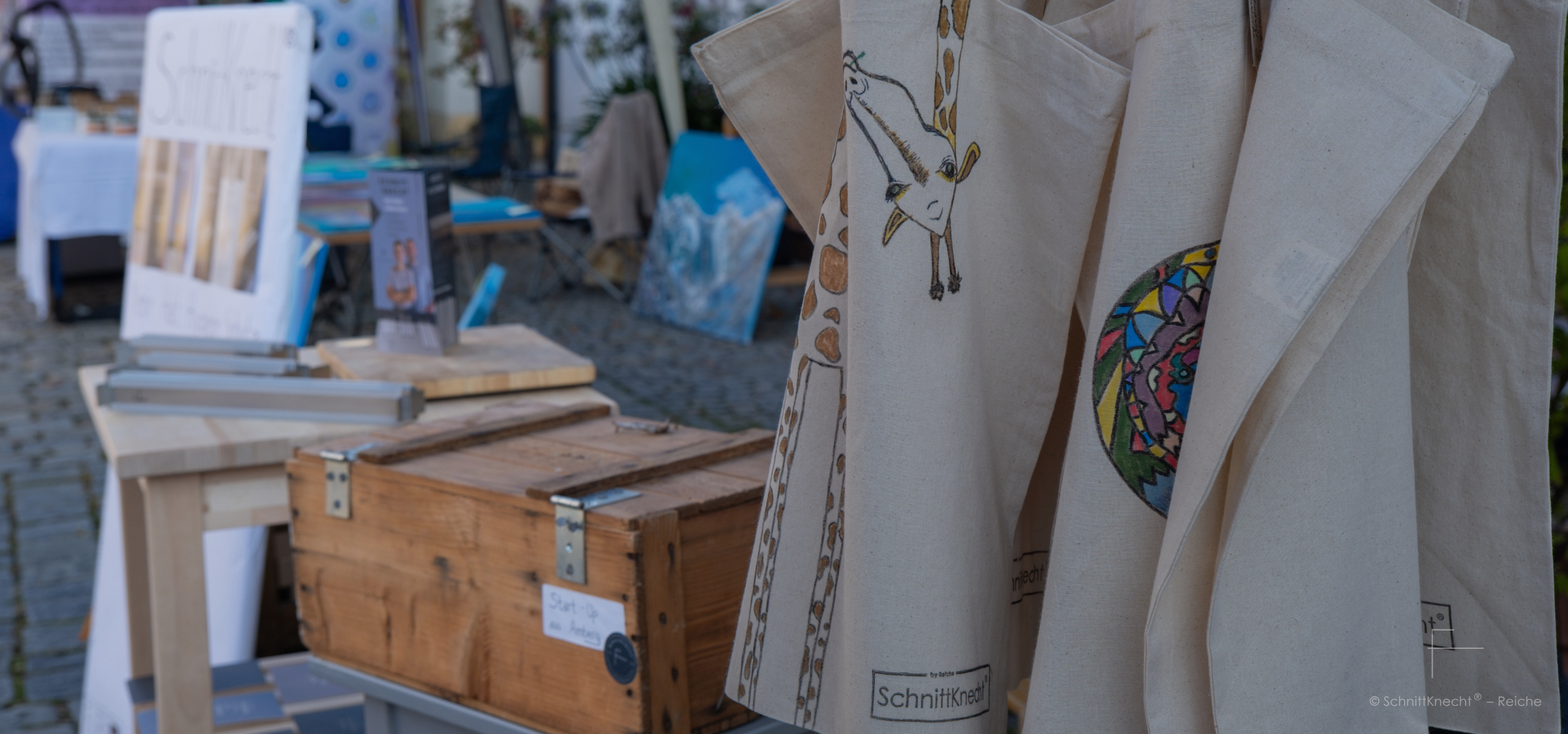 Schnittknecht® Cotton Bags im Vordergrund, selbst bemalte Stofftaschen als DIY-Idee, dahinter Schneidebrettunterlagen für mehr Halt, Hygiene und Schutz